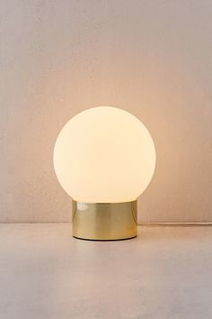 a white light sitting on top of a table next to a wall and a chair