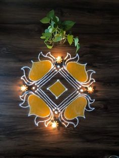 a plant is growing out of the center of a decorative design on a wooden surface