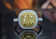 This lovely double halo Fancy Yellow Diamond Ring features a 1.50 Ct. natural fancy yellow cushion cut diamond with VS2 clarity. Surrounding the center gem and the shank are 1.00 Ct. of round cut fancy yellow and white diamonds in U-Pave setting. Metal : 14K Gold, 18K Gold, Platinum/18KY Setting Type : U-Pave, Prong Total Carat : 2.50 Carats Type : Natural Diamond Shape : Cushion Cut Carat Weight : 1.50 Ct. (GIA Certified) GIA Certificate : Included, Contact us to obtain copy Cut : Excellent Color : Natural Fancy Yellow Clarity : VS2 Type : Natural Diamonds Shape : Round Cut Side Stones : 1.00 Ct. Cut : Excellent Color : E-F, Fancy Yellow Clarity : VS2 Yellow Diamond Ring With Cushion Cut, Yellow Cushion Cut Diamond Ring With Halo Setting, Yellow Cushion Cut Diamond Ring With Center Stone, Fine Jewelry Yellow Diamond Ring With Halo Design, Formal Yellow Cushion Cut Diamond Ring, Yellow Diamond Ring With Halo And Round Cut, Yellow Diamond Ring With Halo Setting And Round Cut, Yellow Diamond Rings With Halo Design, Yellow Diamond Ring With Halo