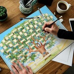 a person is painting a tree on a table with watercolors and pencils