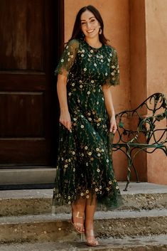 a woman in a green dress standing on steps