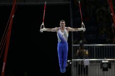 a man is performing on the rings at an event