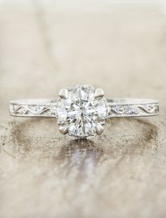 a diamond engagement ring sitting on top of a wooden table