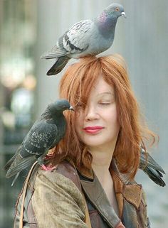 a woman with red hair and two pigeons on her head