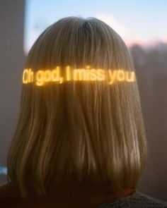 the back of a woman's head with words projected on it that read, oh god i miss you