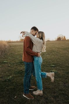 a man and woman embracing in the grass