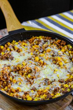 a skillet filled with food sitting on top of a wooden cutting board