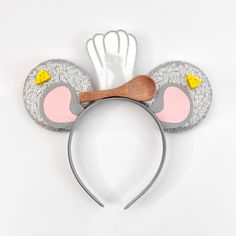 a mouse ears headband with a wooden spoon sticking out of it's side