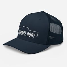 the square body trucker hat is shown in navy and white with an embroidered logo