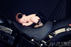 a baby is sleeping on top of a motorcycle seat with a black lace garter