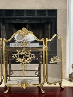 an ornate gold mirror sitting on top of a wooden table in front of a fireplace