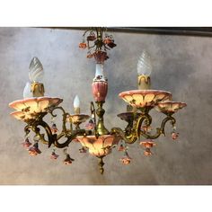 an antique chandelier with pink and gold flowers on it's glass shades