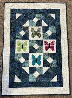 a quilted wall hanging with butterflies on it