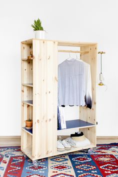 a wooden wardrobe with an open door on the side and shoes in front of it