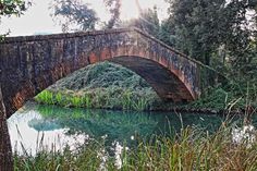 an old stone bridge over a small river