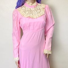 "Womens M Feels like acetate 36\" bust 28\" waist 44\" hips 55\" length 15\" across shoulders 23\" sleeve A gorgeous pastel rose pink 70s high neck maxi dress with lace high collar and cream lace at the wrists. Ties in the back in a big bow. Zips down the back. In great vintage condition, there are a couple of very small and light marks but nothing noticeable." Pink Long Sleeve Dress With Lace Collar, Pink Party Dress With Lace Collar, Feminine Fitted Maxi Dress With Lace Sleeves, Fitted Feminine Maxi Dress With Lace Sleeves, Feminine Pink Dress With Lace Collar, Pink Lace Trim Maxi Dress For Wedding, Pink Lace Trim Wedding Maxi Dress, Pink Vintage Long Sleeve Dress With Lace Trim, Pink Vintage Dress With Lace Trim And Long Sleeves