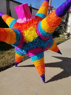 an odd looking object made out of paper on the side of a road in front of a house