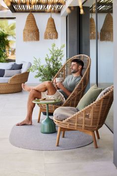 a man sitting in a wicker chair on a patio