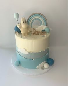 there is a cake that has an animal on top and balloons in the air above it