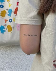 a woman with a tattoo on her arm that says we'll be alright in cursive writing