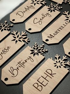 wooden name tags with snowflakes on them sitting on top of a black table