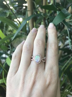 "An oval-shaped natural and genuine Opal set in a bezel setting accented with petite white sapphires handcrafted in your choice of 10k/14k/18k Rose/Yellow Gold or White Gold. This ring makes a lovely engagement/promise/October birthstone/statement ring. Wrapped in a Box ready for gift giving.(r-egt-20) Please note each opal has a unique play of color, if you wish for a certain color in the fire, please let us know and we will try to accommodate your request. View our Instagram video of this Ring Oval Opal Ring For Anniversary, Diamond Oval Birthstone Ring As A Gift, Oval Diamond Birthstone Ring As A Gift, Diamond Birthstone Ring Gift With Oval Shape, White Oval Jewelry With Bezel Setting, Oval Opal Promise Ring With Accent Stones, Oval Opal Promise Ring, Oval Opal Rings With Bezel Setting, Oval Cubic Zirconia Birthstone Ring Gift