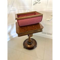 a wooden stand with a pink cushion on it