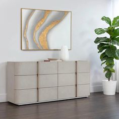 a living room scene with focus on the sideboard and large plant in the foreground