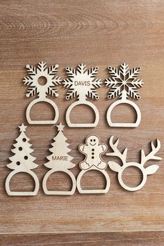 wooden cutouts with snowflakes, reindeers and trees in them on a table