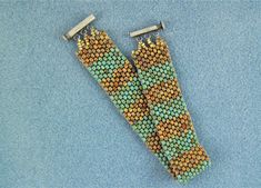 two pairs of beaded earrings sitting on top of a blue surface