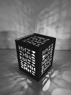 a black and white photo of a cube shaped object with geometric designs on the sides