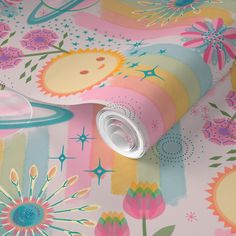 a colorful wallpaper with flowers on it and a vase next to it that has a cup in the middle