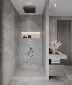 a bathroom with marble walls and flooring, including a shower head in the corner