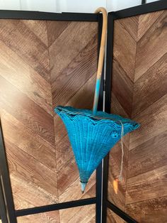 a blue umbrella sitting on top of a wooden floor next to a wall mounted tv