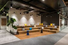 an office lobby with wooden benches and planters on the floor, surrounded by brick walls