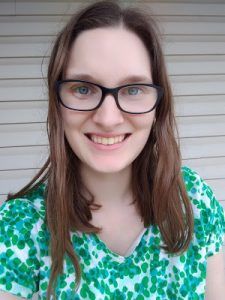 a woman with glasses is smiling for the camera