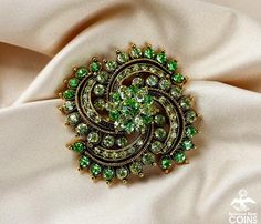 ..................................Weight: 37.7 gramsMeasurements: 2.30" Diameter; 0.70" DeepStone: Green Rhinestone*This vintage Fashion Jewelry brooch features bright and glittering yellow & green rhinestones with gold tone, floral wreath-like design. This brooch is in great condition, with little to no wear and patina. The clasp works nicely. This stunning brooch would make an excellent gift for a loved one.. or better yet, an oh-so-delicious treat for yourself! Add spark to your outfit wi Green Jeweled Brooch For Gift, Green Brooch For Party, Green Jeweled Brooches As Gift, Green Rhinestone Wedding Brooch, Green Rhinestone Wedding Brooches, Elegant Green Rhinestone Brooches, Formal Green Rhinestone Brooches, Green Brooch Jewelry For Evening, Green Evening Brooch Jewelry