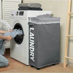 a person kneeling down in front of a washing machine with the words laundry on it