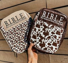 two bible covers with the word bible printed on them are held up by a person's hand