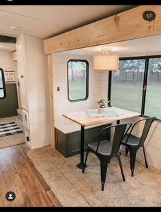 the interior of a mobile home with wood flooring and black chairs in front of windows