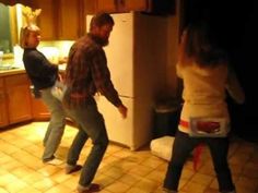 two people are dancing in the kitchen at night