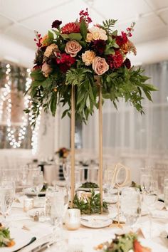 a tall centerpiece with flowers and greenery