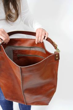 Cognac brown leather hobo This brown large tote bag is made from high quality italian leather. Spacious interior provides room for all the daily essentials and more. There is an inside zippered pocket. This bag is perfect as your everyday bag, which can fit an IPAD, laptop, A4 files, books, magazines, cosmetic bag as well as many accessories. This bag has top zipper closure for safety. Height: 18,5 inch (47 cm) Width: 18,1 inch (46 cm) Length of handle: 19,3 inch (49 cm) Bottom width: 13,4x 5,5 On-the-go Cognac Hobo Bag With Removable Pouch, Brown Bucket Bag With Zipper Pocket For Everyday, Brown Hobo Bucket Bag With Removable Pouch, Brown Soft Leather Hobo Bag For On-the-go, Cognac Bucket Bag With Leather Lining For On-the-go, Cognac Hobo Bag With Leather Handles For Errands, Cognac Soft Leather Hobo Bag For Errands, Cognac Leather Bag With Zipper Pocket, Everyday Cognac Hobo Bag With Leather Lining