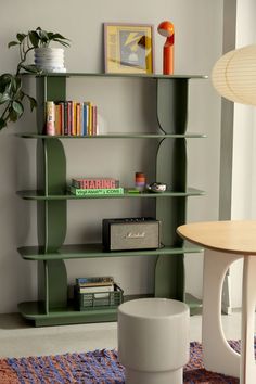 a living room with a book shelf and a table in the corner next to it