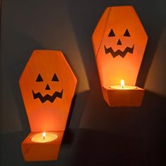 two paper lanterns with faces on them, one is lit and the other has a candle