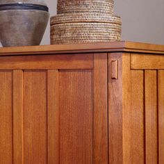 two baskets on top of a wooden cabinet