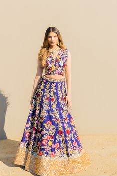 Mrunal - Navy Blue Modern Indian Bridal Lengha Choli w/ handwork Paint your life with this multicolor embroidered this stunning navy blue lengha that is bound to make you stand out! V-neck choli blouse w/ tie back & colorful floral work Multicolor floral choli blouse Modern bridal v-neck design Sequins accents the embroidery Contemporary sleeveless blouse Gorgeous netted tie-back blouse Edgy trim adding uniqueness Navy-blue gored skirt lengha with floral embroidery Traditional deep blue skirt le Blue Bohemian Lehenga With Traditional Drape, Blue Bohemian Choli For Designer Wear, Royal Blue Bollywood Choli With Intricate Embroidery, Bollywood Style Royal Blue Embroidered Choli, Blue Bohemian Lehenga For Party, Blue Bohemian Traditional Wear With Floral Embroidery, Bohemian Blue Traditional Wear With Floral Embroidery, Bohemian Blue Choli For Wedding, Bohemian Blue Set With Floral Embroidery