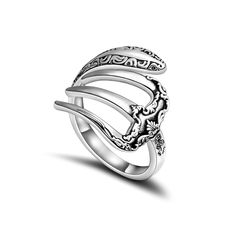 a silver ring with an intricate design on the front and sides, set against a white background