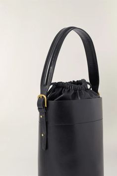 Black leather bucket bag- Hand, shoulder, or cross-body bag- Golden metallics- Fastens with an inner leather drawstring pouch- Height 26 cm, depth 18 cm- One removable leather handle - length 77 cm - One removable cotton handle - length 106 cm Modern Bucket Shoulder Bag With Leather Handles, Bucket Bag With Leather Round Handles For Shopping, Modern Bucket Bag With Leather Handles For Shopping, Modern Bucket Bag With Leather Round Handles, Luxury Leather Bucket Bag With Handles, Modern Bucket Bag With Round Handle For Everyday Use, Shopping Bucket Bag With Leather Round Handles, Modern Bucket Bag With Round Leather Handles, Shopping Bucket Bag With Round Leather Handles