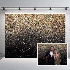 an image of a man and woman standing in front of a backdrop with gold glitter